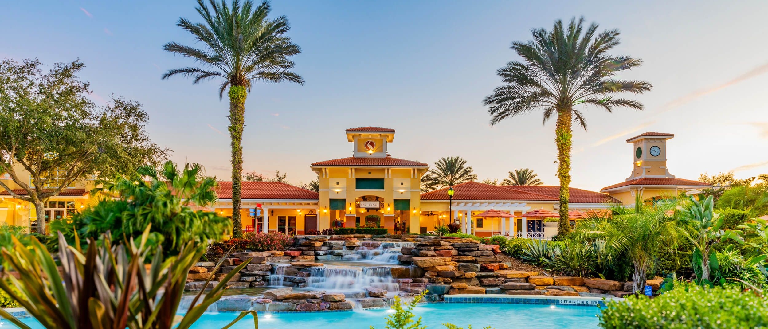 Resort pool and beachfront villas at sunset